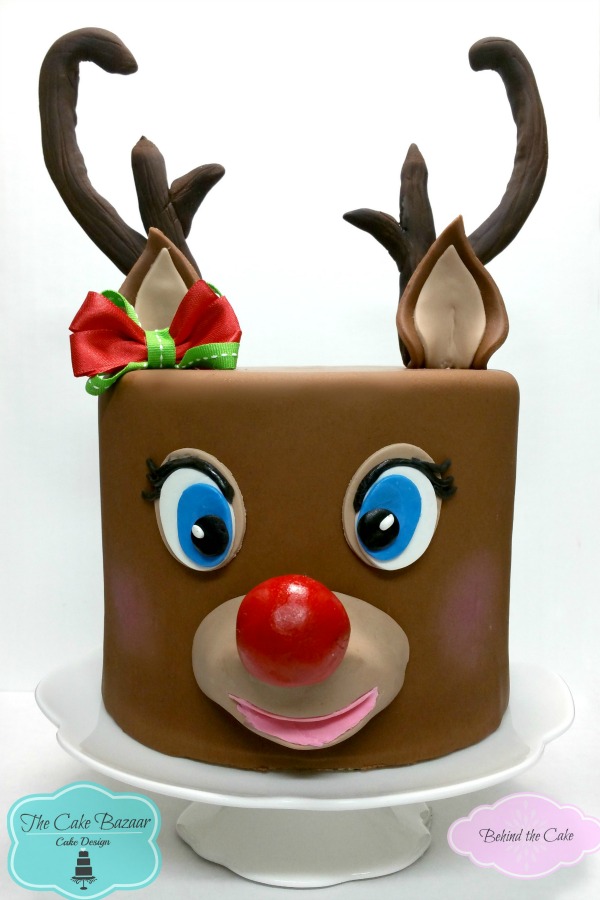Behind the cake - Cake decorated with fondant as a reindeer cake with molded antlers and red nose