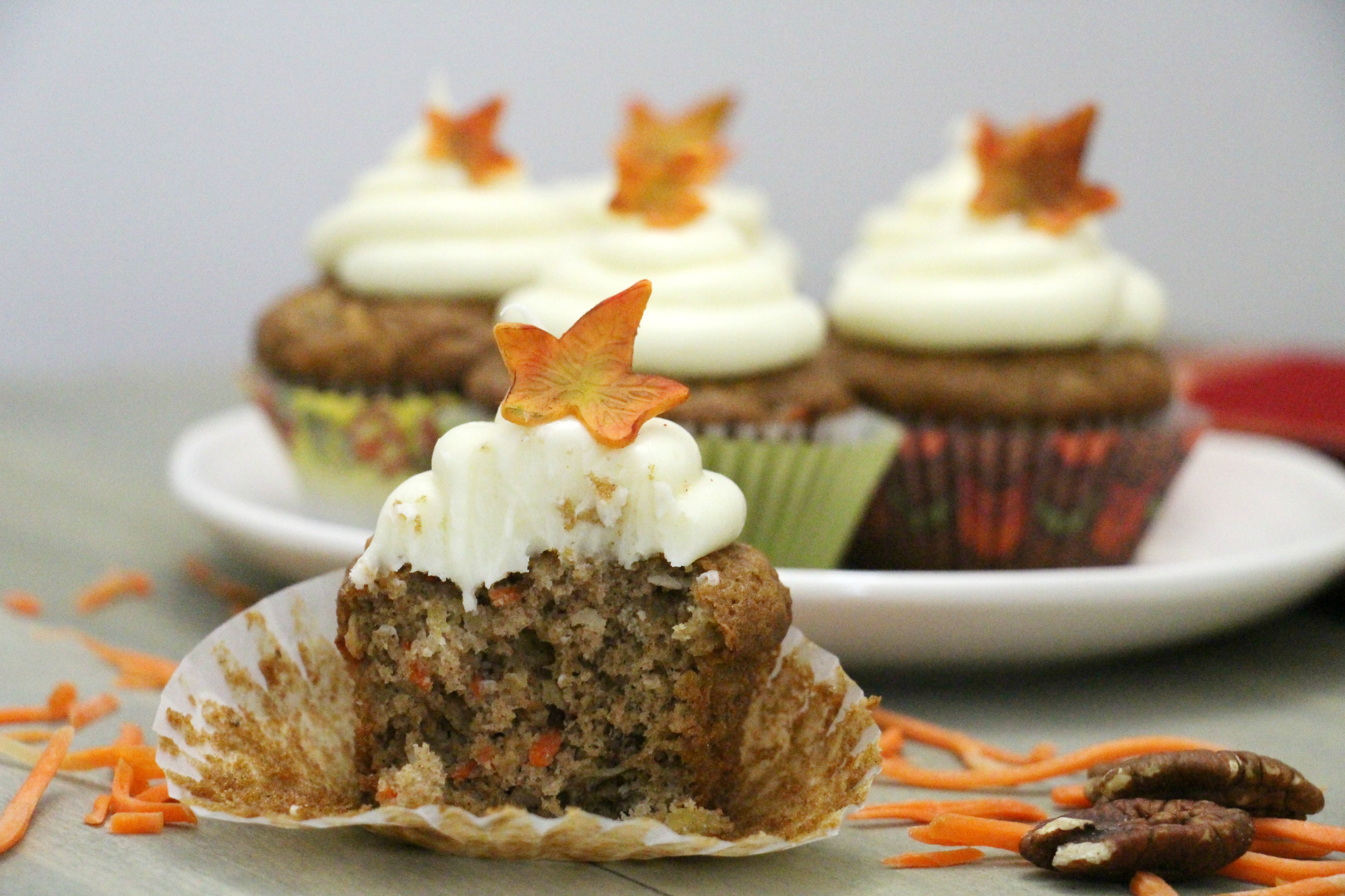 Behind the cake - Carrot cake cupcakes frosted with cream cheese and decorated with a fondant fall leaf